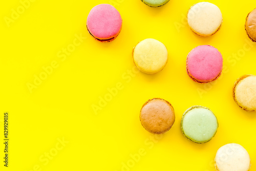 Macarons dessert pattern on yellow background top view copy space