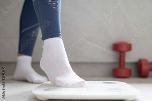 A person is standing on a scale in the bathroom

