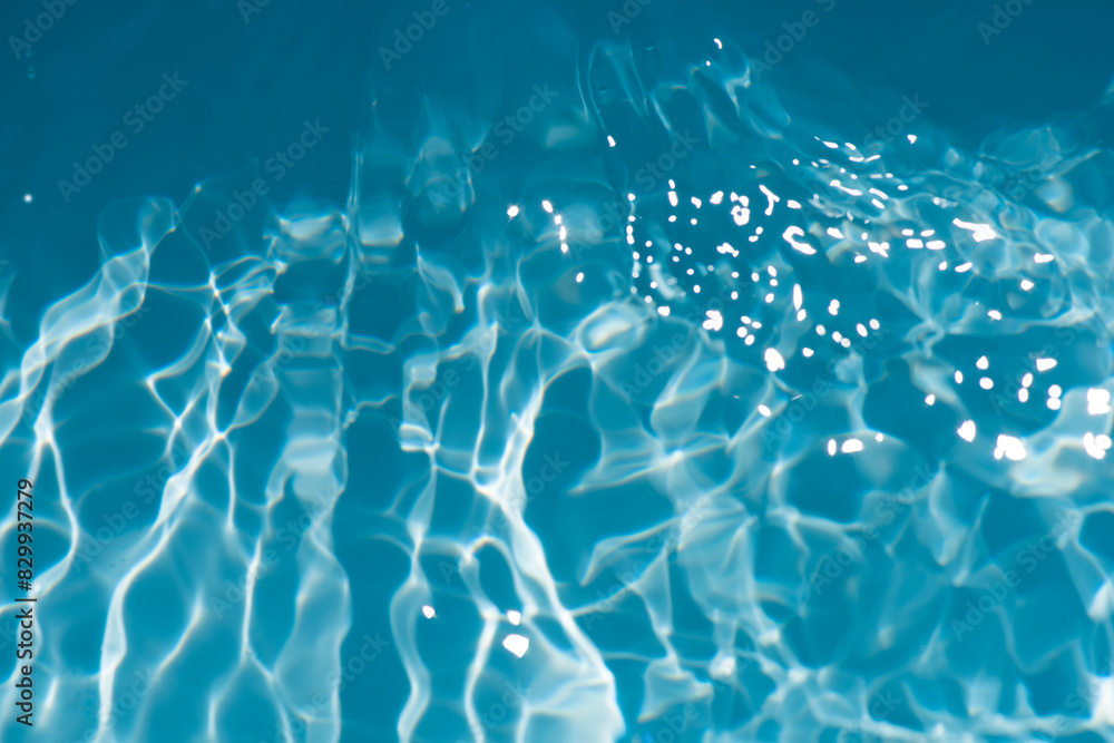 Blue water with ripples on the surface. Defocus blurred transparent blue colored clear calm water surface texture with splashes and bubbles. Water waves with shining pattern texture background. Blue water with ripples on the surface. Defocus blurred transparent blue colored clear calm water surface texture with splashes and bubbles. Water waves with shining pattern texture background.