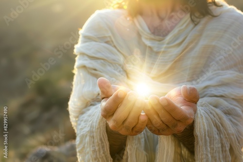 A person in a robe holds a glowing light in their hands, symbolizing hope and spirituality