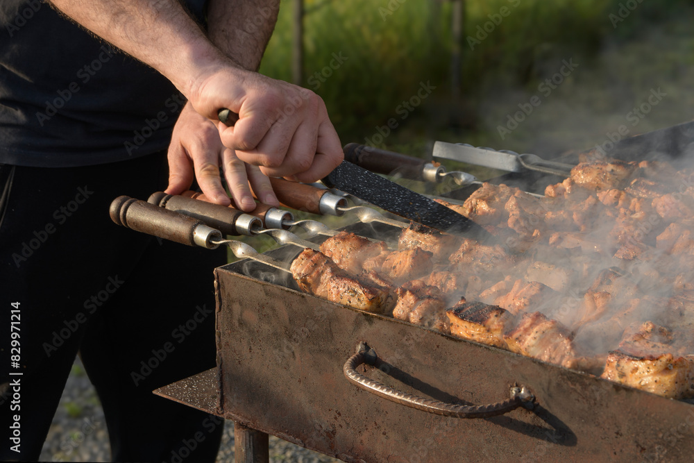 Fototapeta premium Cooking large pieces of meat over charcoal by deep-frying them