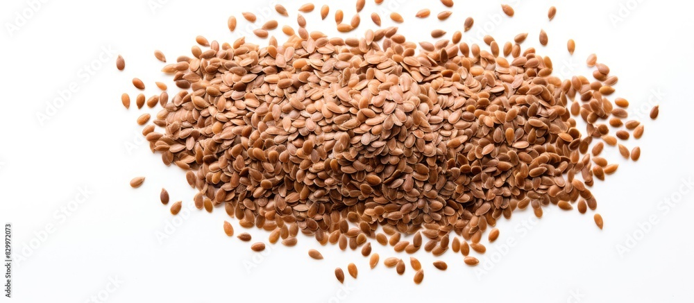 A healthy food concept featuring a white background with raw flax seeds scattered in a random pattern providing ample space for additional content A healthy food concept featuring a white background with raw flax seeds scattered in a random pattern providing ample space for additional content