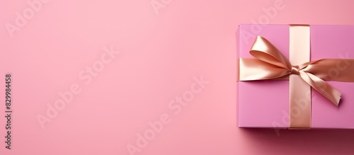 A close up top view of a pink gift box against a background with ample copy space for adding text
