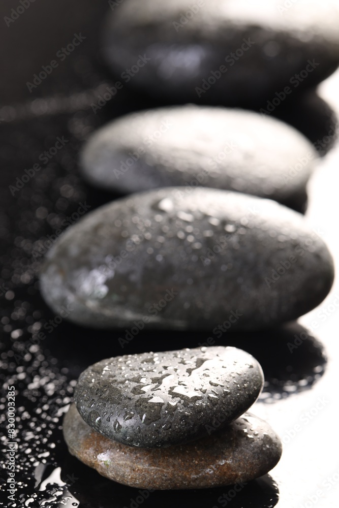 Grey spa stones with water drops on black background, closeup Grey spa stones with water drops on black background, closeup