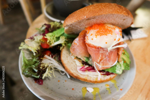 closed up of smoked salmon avocado and onsen egg bagel with wasabi cream sauce salad taken in a cafe