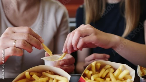 Mom And Young Daughter Enjoying Fries With Sauce At A Fast Food Joint