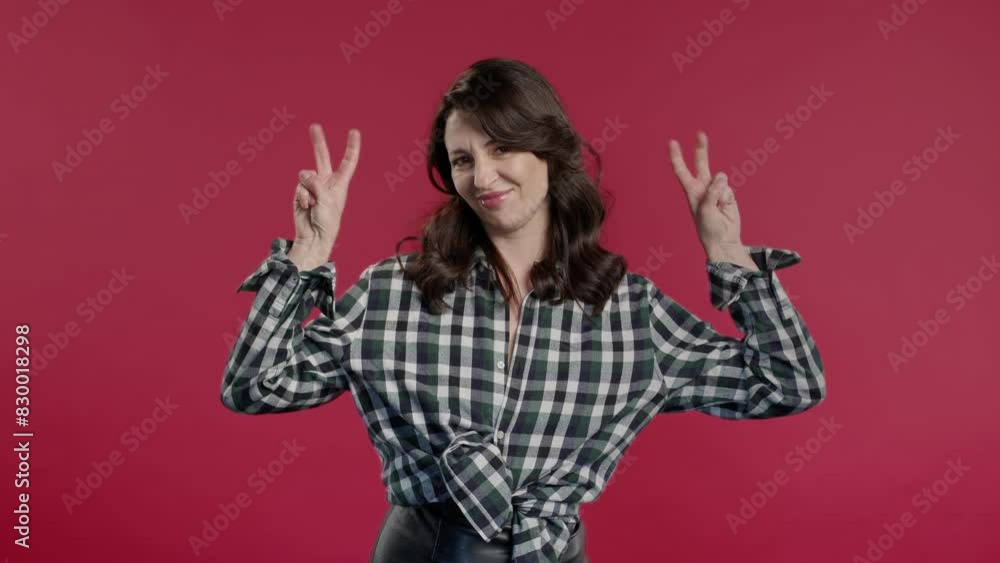 Attractive 40s woman with hands two fingers air quotes gesture on red, sarcasm Attractive 40s woman with hands two fingers air quotes gesture on red, sarcasm