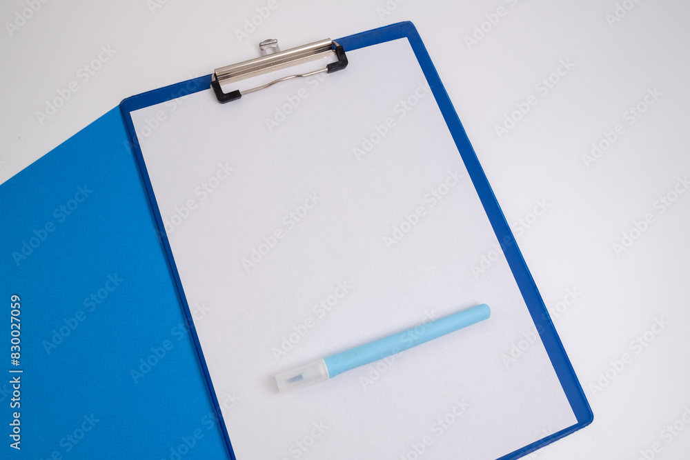 Blank tablet with a white sheet and a pen on a light background. A4 holder. Stationery. Blank document holder with space for text. Mockup Blank tablet with a white sheet and a pen on a light background. A4 holder. Stationery. Blank document holder with space for text. Mockup