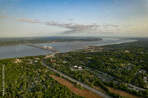 Highway Bisects a Green Forest Leading to a Bridge that Crosses a River under a Sunrise