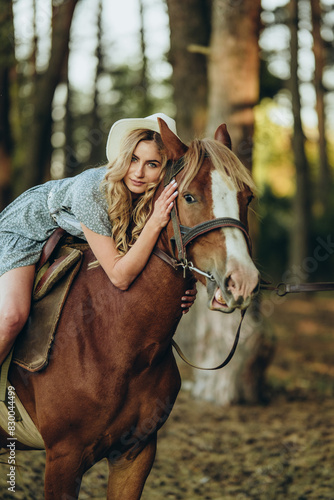 A young beautiful woman rides a horse in the forest in autumn. Horseback riding in the evening in autumn.