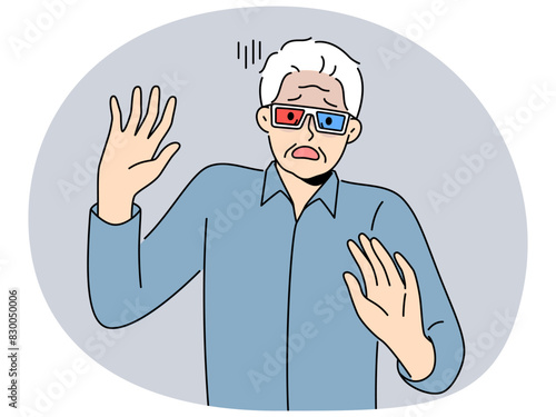 Elderly man in cinema glasses gets scared sees 3d special effects in movie for first time. Grey-haired pensioner in glasses exclaims and waves hands watching modern film with 3d effect