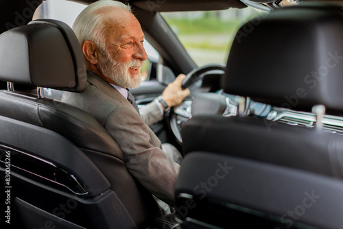 Distinguished elderly gentleman driving in a modern city on a sunny afternoon