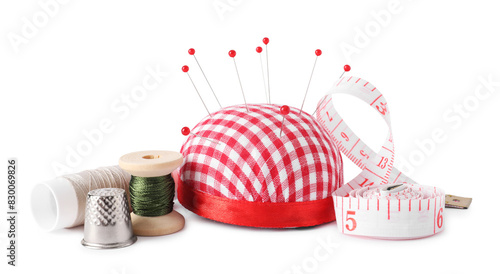 Pincushion, sewing pins, measuring tape, spools of threads and thimble isolated on white