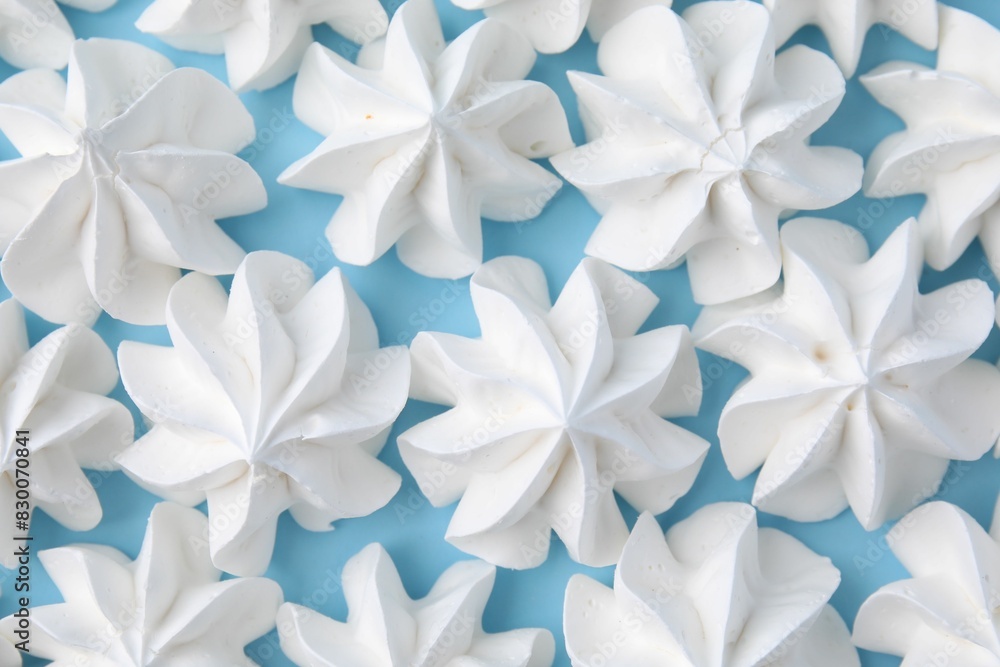 Tasty meringue cookies on light blue background, flat lay Tasty meringue cookies on light blue background, flat lay