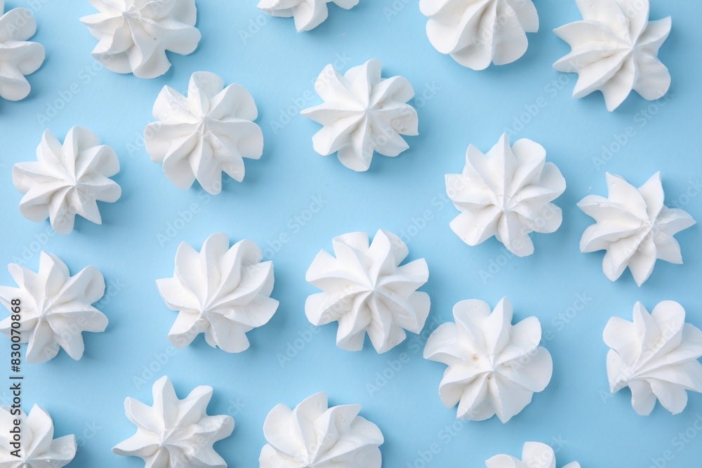 Tasty meringue cookies on light blue background, flat lay Tasty meringue cookies on light blue background, flat lay