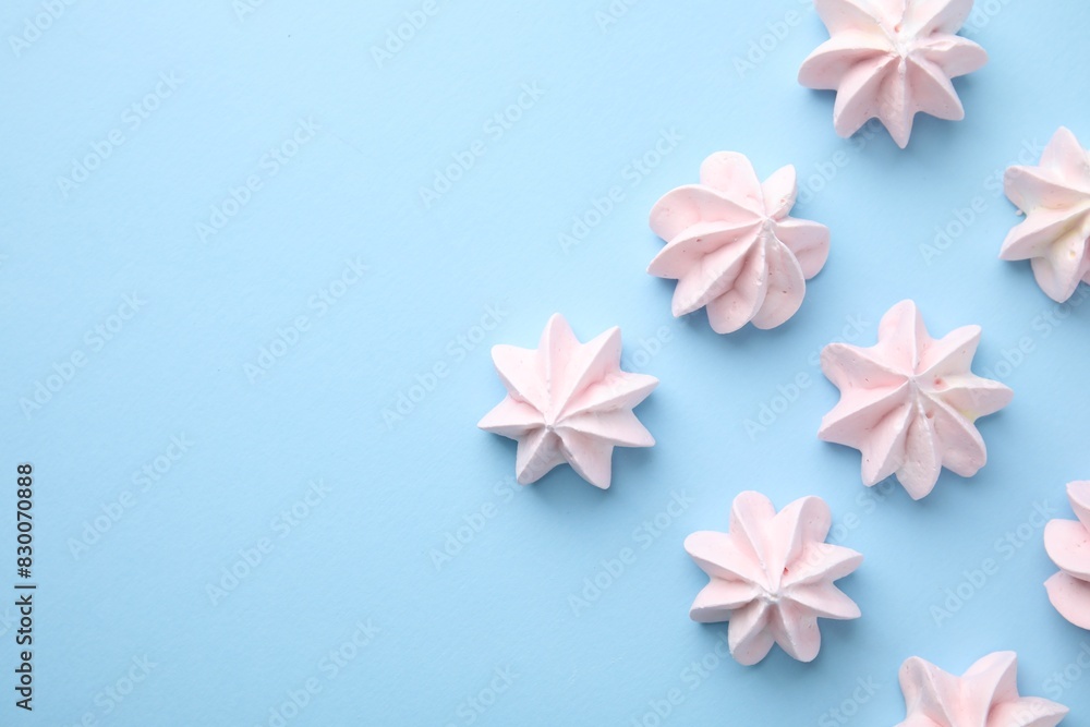 Tasty meringue cookies on light blue background, flat lay. Space for text Tasty meringue cookies on light blue background, flat lay. Space for text