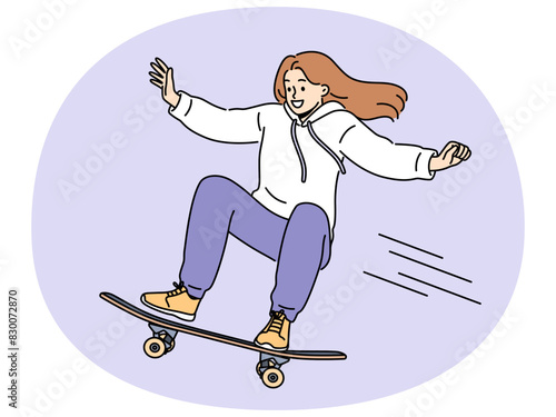 Brave girl skateboarder makes aerial stunt by bouncing on ramp in skatepark. Smiling young woman riding skateboard and enjoying extreme sports wanting to become professional skateboarder