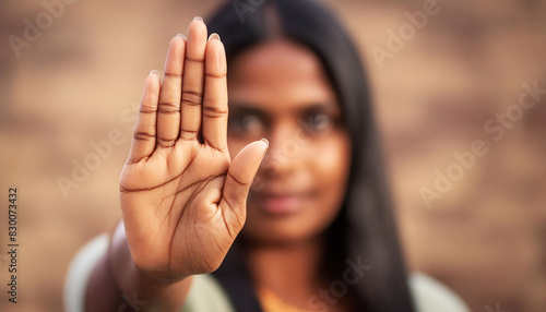 Indian woman's hand with fingers spread out close to the camera, open palm, making a stop gesture or showing number five, attention, warnings, instructions, photo