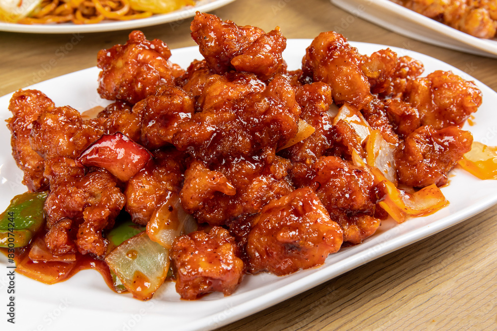 A plate of General tso chicken, a Chinese dish of breaded chicken with sweet and tangy red sauce in honor of the legendary General tso A plate of General tso chicken, a Chinese dish of breaded chicken with sweet and tangy red sauce in honor of the legendary General tso