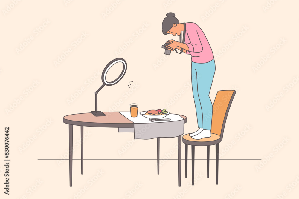 Woman takes photographs food, standing on chair to obtain pictures of dishes for restaurant menu Woman takes photographs food, standing on chair to obtain pictures of dishes for restaurant menu