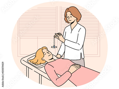 Psychiatrist hypnotizes female patient to treat psychological problems caused by difficult childhood. Girl lies on couch with eyes closed while undergoing hypnotizes therapy and arriving in trance