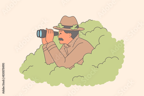 Man private detective is investigating case of adultery, looking out of bushes with binoculars