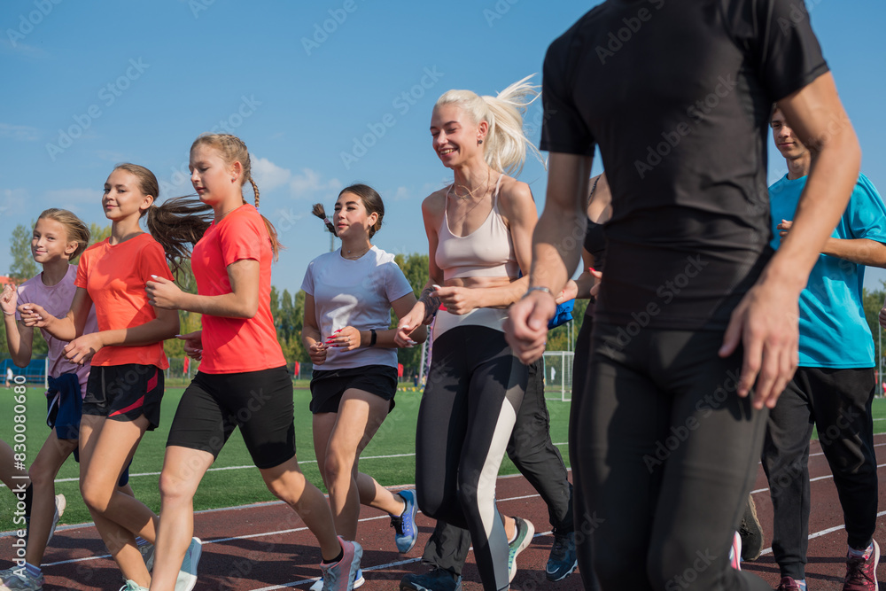 Group of young athletes training at the stadium. School gym trainings or athletics Group of young athletes training at the stadium. School gym trainings or athletics