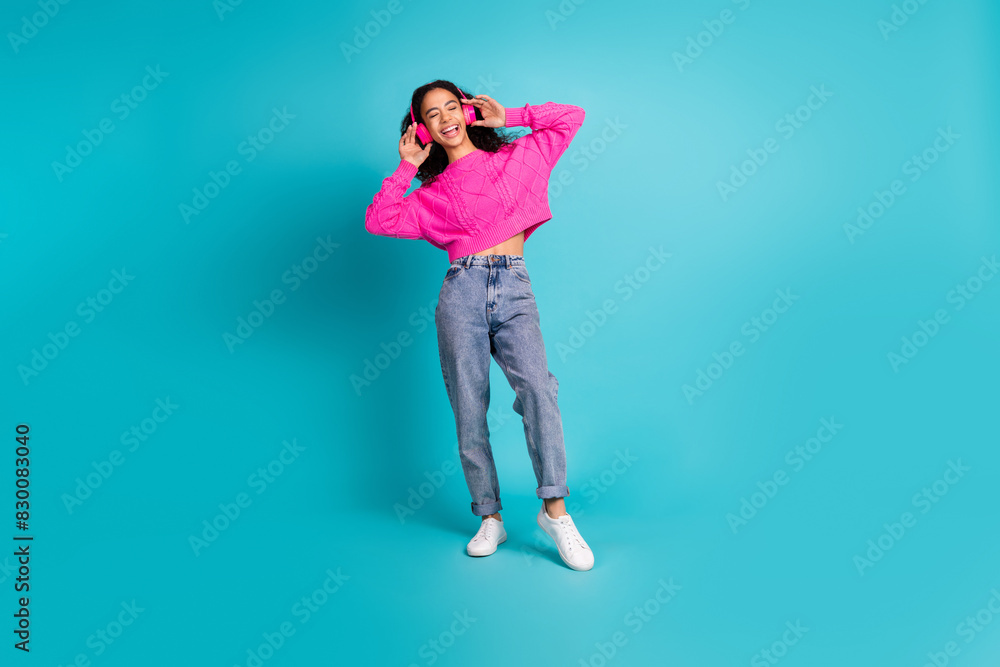 Full length photo of lovely teen lady dancing earphones music dressed stylish pink garment isolated on cyan color background Full length photo of lovely teen lady dancing earphones music dressed stylish pink garment isolated on cyan color background
