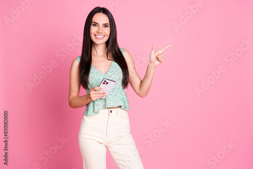 Photo of lovely adorable woman user wear trendy clothes introduce empty space isolated on pink color background © deagreez