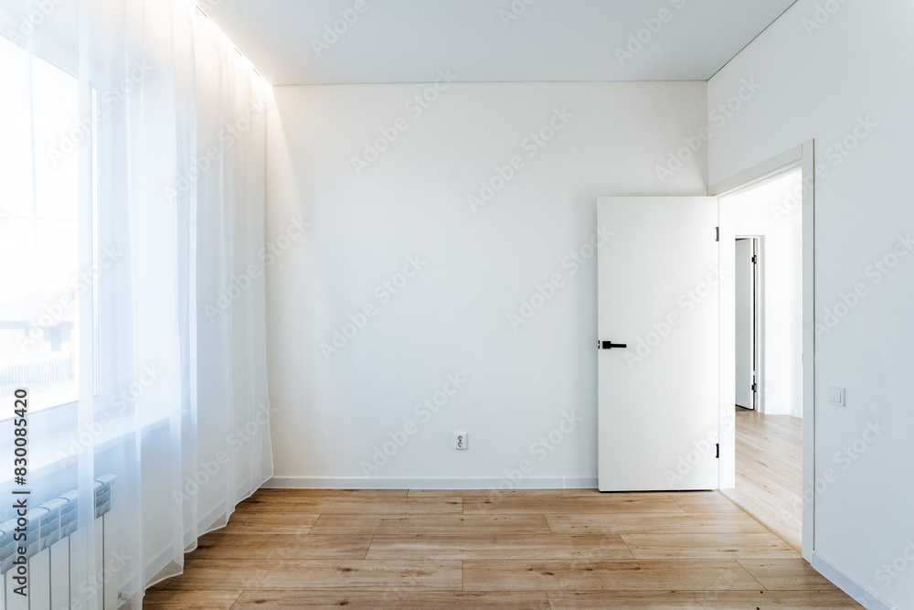 Fototapeta premium Imagine a modern, bright room with an open door, wooden flooring, white walls, and abundant natural light. Perfect for interior design inspiration and real estate listings