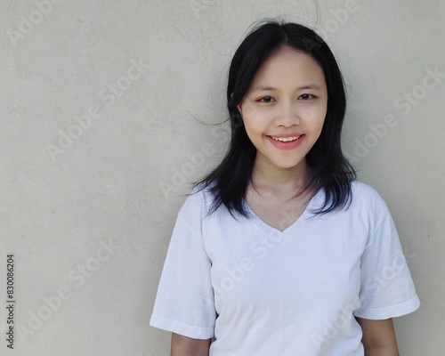 Horizontal portrait Waist up shot young asian woman with dark hair, smiling, confident, dressed in casual, looking straight at camera. Lifestyle concept