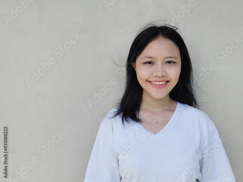 Horizontal portrait Waist up shot young asian woman with dark hair, smiling, confident, dressed in casual, looking straight at camera. Lifestyle concept