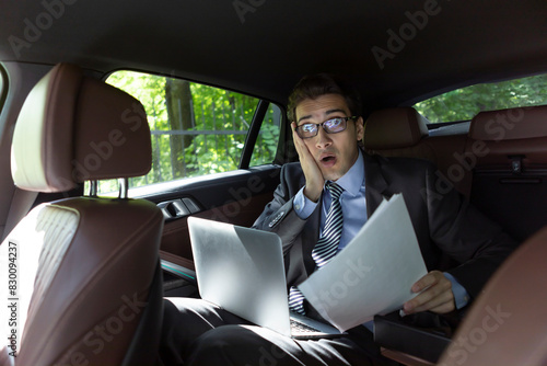 Depressed businessman sitting on backseat of his luxury car and feeling bad after overloaded work day in the office © Vitaliy