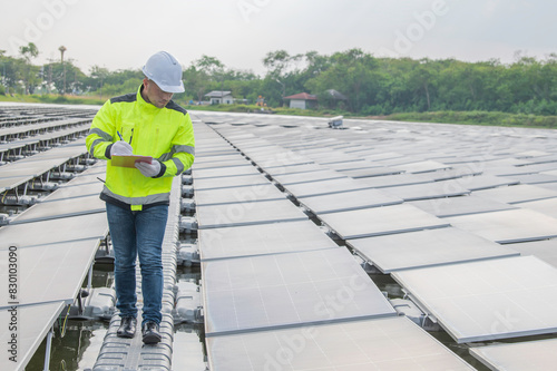 Engineer working at floating solar farm,checking and maintenance with solar batteries near solar panels,supervisor Check the system at the solar power station © reewungjunerr