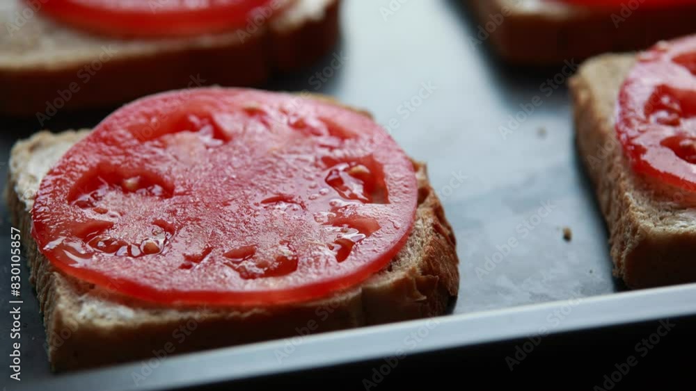 woman assembles sandwiches with tomato, salami, and cheese to bake in a pan sheet in this close-up stock video woman assembles sandwiches with tomato, salami, and cheese to bake in a pan sheet in this close-up stock video