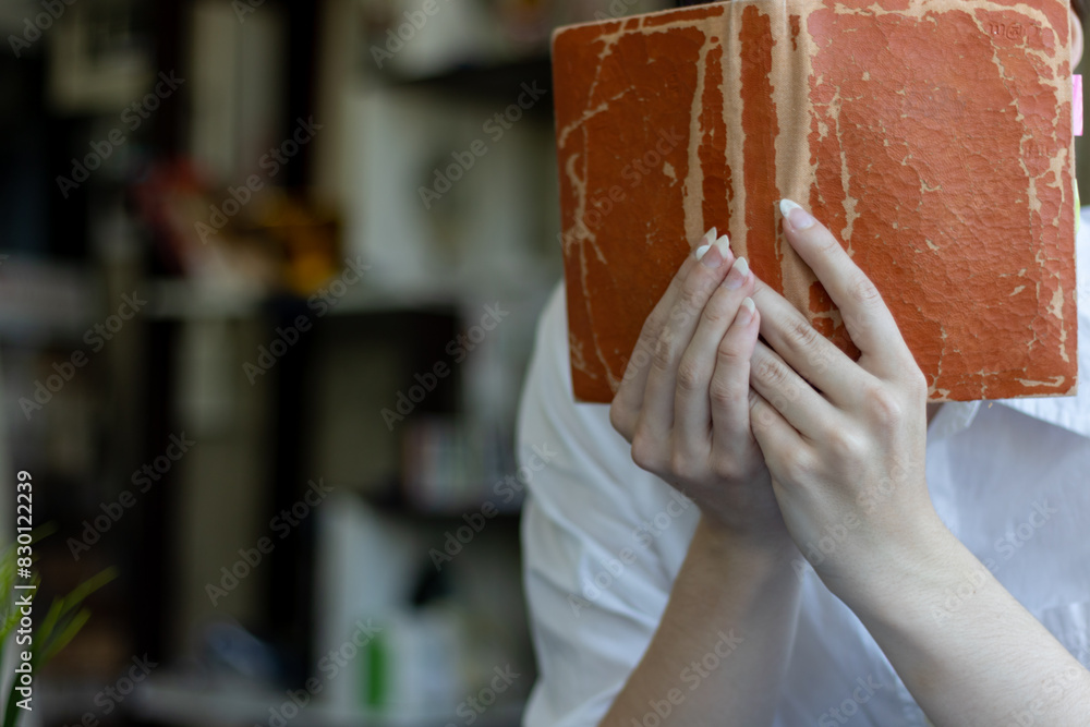 Obraz premium The young woman held a Bible in her hand and tried to learn and understand God teachings from the Bible she held. Concepts of belief and the power of faith in God and teachings from the Bible.