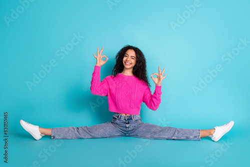 Full length photo of lovely teen lady sit floor split okey dressed stylish pink garment isolated on cyan color background © deagreez