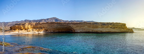 Panoramic view of Cala Blanca beach in the Puntas de Calnegre regional park in the Region of Murcia, Spain with its typical cave houses and transparent waters photo