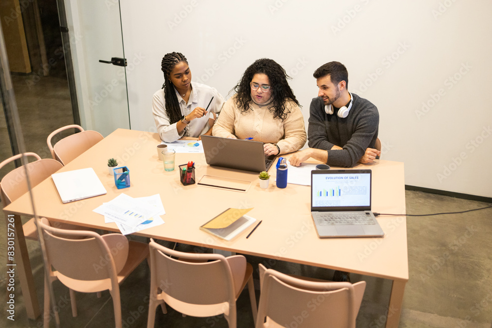 Diverse team collaborating in a modern coworking space Diverse team collaborating in a modern coworking space