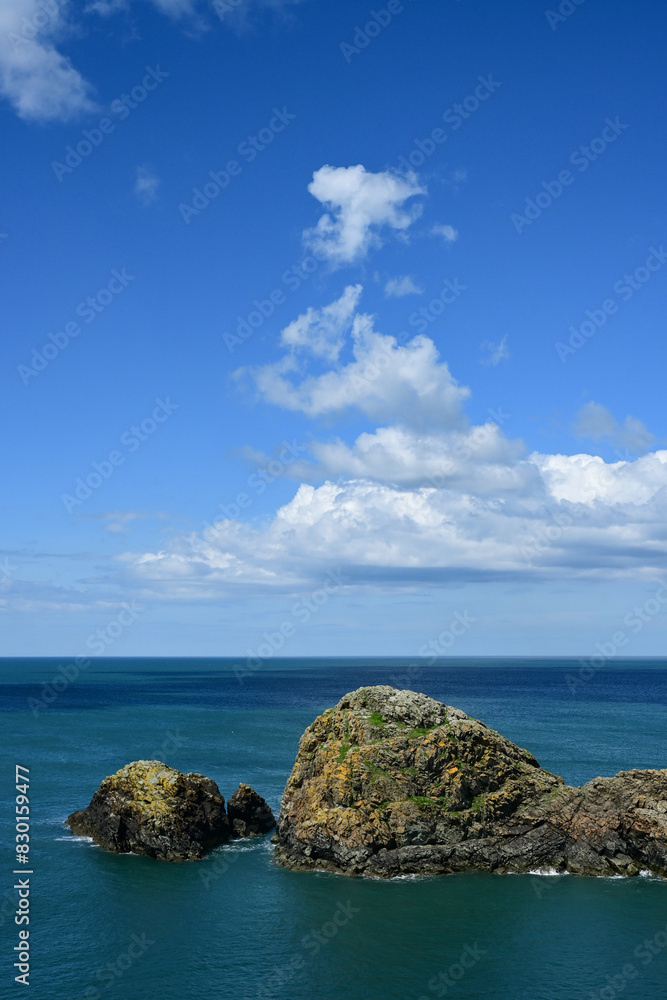 Fototapeta premium Rocky Coast Under Fluffy Clouds, Pembrokeshire, Wales, UK .
