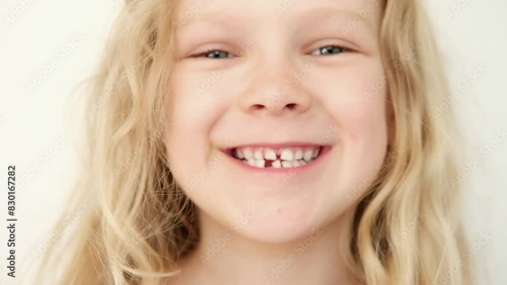 portrait Blonde haired curly caucasian baby girl without first milk tooth in mouth. stomatology. kid loses his first tooth. children Toothless smile portrait Blonde haired curly caucasian baby girl without first milk tooth in mouth. stomatology. kid loses his first tooth. children Toothless smile