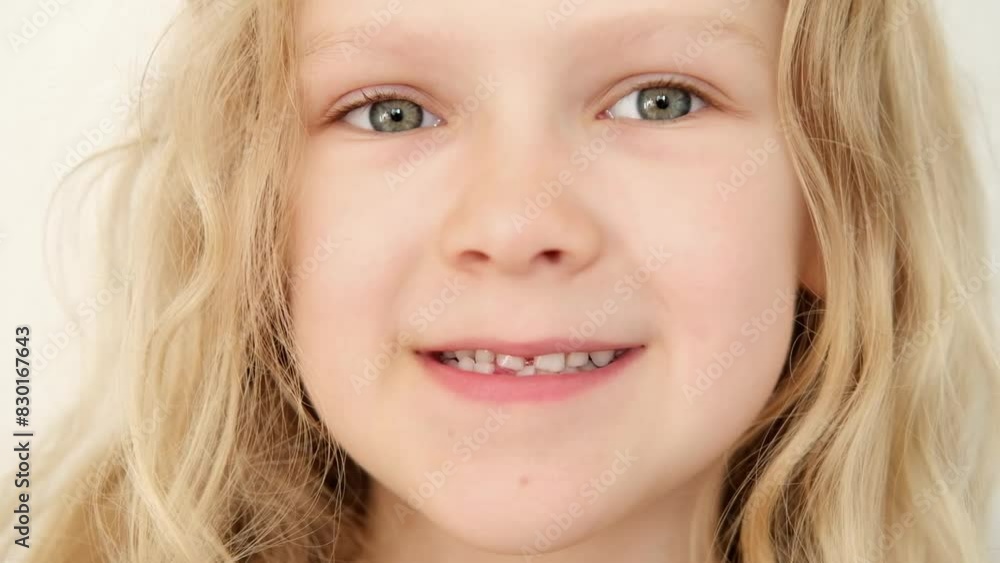 portrait Blonde haired curly caucasian baby girl without first milk tooth in mouth. stomatology. kid loses his first tooth. children Toothless smile portrait Blonde haired curly caucasian baby girl without first milk tooth in mouth. stomatology. kid loses his first tooth. children Toothless smile