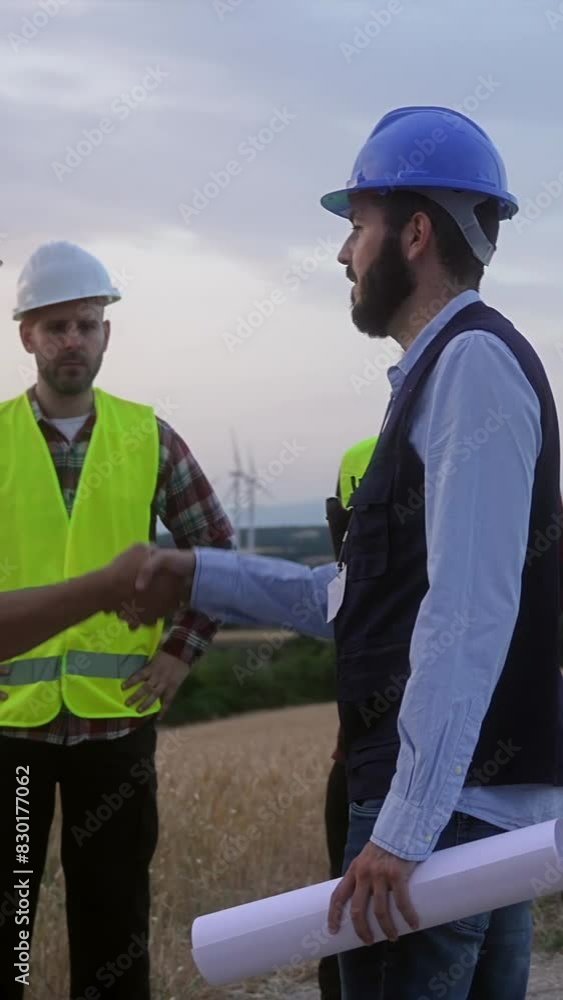 Chief engineer meeting electrical technicians and specialist workers at wind turbine electricity farm - Team of professionals working industry project Chief engineer meeting electrical technicians and specialist workers at wind turbine electricity farm - Team of professionals working industry project