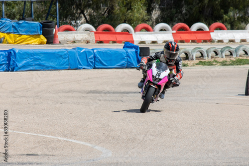 Motorcycle Racer on Pink Bike Taking Turn (ID: 830188200)