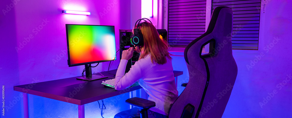 Asian woman gamer wearing gaming headphones holding joystick console to play video game and streaming online on computer PC neon light at home, tournament player E-Sport concept Asian woman gamer wearing gaming headphones holding joystick console to play video game and streaming online on computer PC neon light at home, tournament player E-Sport concept