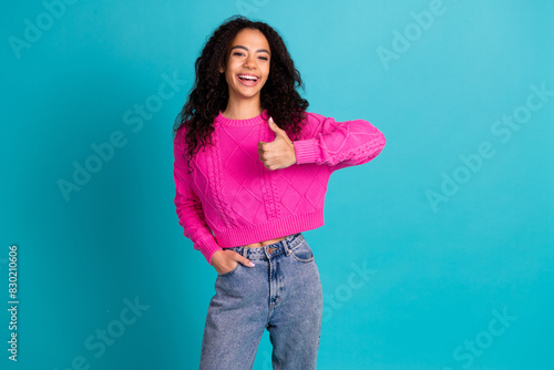 Portrait of nice young girl show thumb up empty space wear pink pullover isolated on turquoise color background © deagreez
