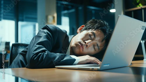 オフィスで仕事に疲れて居眠りするビジネスマン