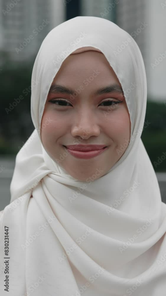 Vertical Video. Portrait of the Beautiful Young Cute Smiling Girl Wearing Hijab. Face. Make Up. Attractive Islamic Lady Outside Standing and Looking to the Camera. Close Up. People Concept. Vertical Video. Portrait of the Beautiful Young Cute Smiling Girl Wearing Hijab. Face. Make Up. Attractive Islamic Lady Outside Standing and Looking to the Camera. Close Up. People Concept.