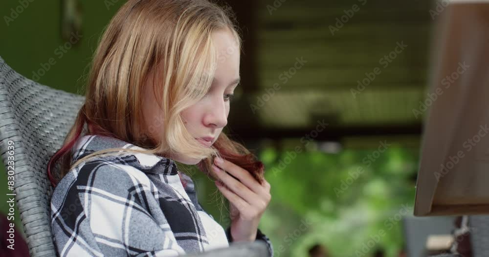 Teen girl surfing in internet looking at smartphone or tablet screen sitting on terrace of country house. Blonde teenager browsing in phone, chatting. Digital entertainment on nature, leisure relax. Teen girl surfing in internet looking at smartphone or tablet screen sitting on terrace of country house. Blonde teenager browsing in phone, chatting. Digital entertainment on nature, leisure relax.