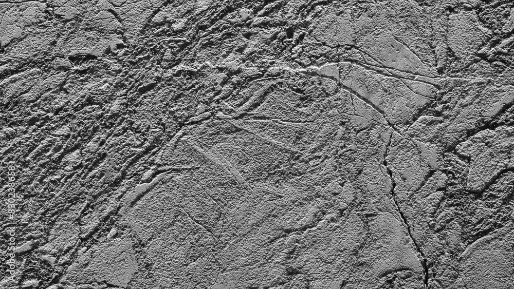 Fototapeta premium A grey stone wall with a rough texture. The wall is covered in small, jagged rocks